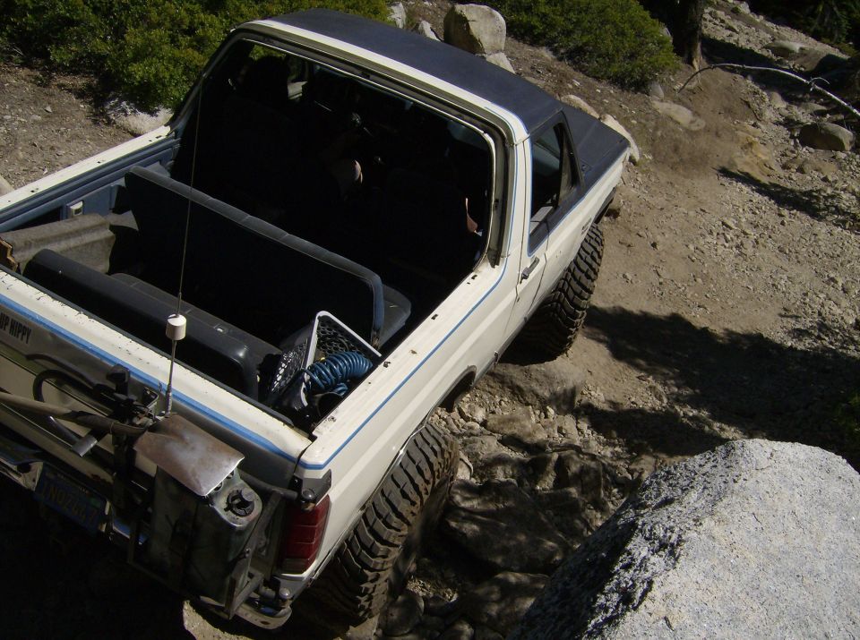White 1986 Ford Bronco navigating a rocky off-road trail