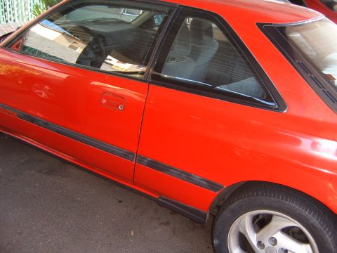 2001 Pontiac Trans Am - A red coupe is shown from the side, with black trim along the body and a visible rear wheel.