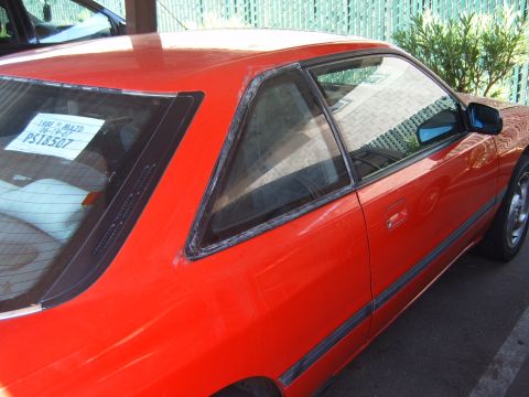 2001 Pontiac Trans Am - Side view of a red coupe, showing a sticker with vehicle information on the rear window.