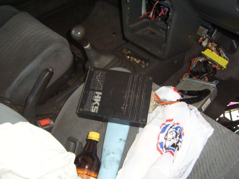 2001 Pontiac Trans Am - The interior of a car shows aftermarket electronics and a bottle, with no clear year identification.