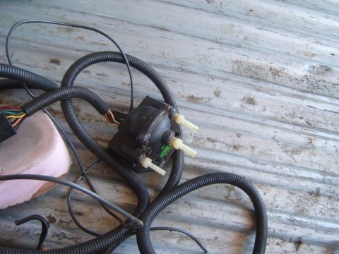 2001 Pontiac Trans Am - A close-up of a vacuum pump and associated wiring harness, possibly for a vehicle, is shown resting on a textured surface.