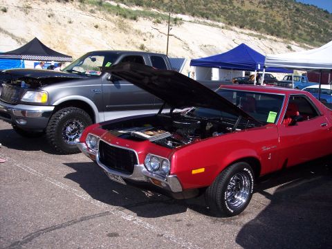 1972 Ford Ranchero - Two vehicles are parked side-by-side with their hoods up at an outdoor event.