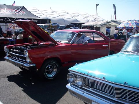 1972 Ford Ranchero - Two classic Ford cars, a red 1966 Fairlane and a blue 1964 Galaxie, are displayed at an outdoor event.