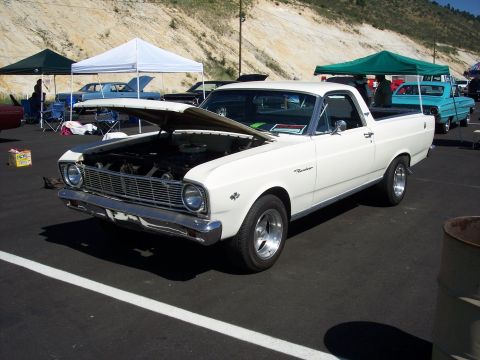 1972 Ford Ranchero - A white Ford Ranchero is parked with its hood open at an outdoor event.
