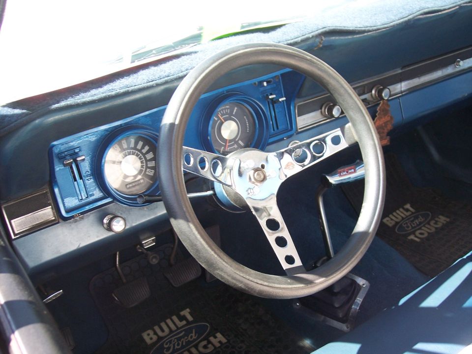 1972 Ford Ranchero interior showing blue dashboard, aftermarket steering wheel, and floor mats that say "Built Ford Tough"