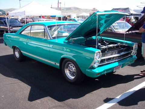 1972 Ford Ranchero - A teal 1966 Ford Fairlane GT is displayed with its hood open at an outdoor event.