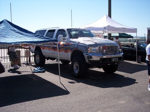 1972 Ford Ranchero - A modified SUV with custom paint and lifted suspension is parked outdoors.