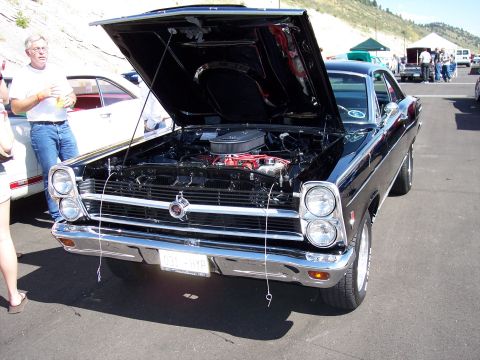 1972 Ford Ranchero - Front view of a black 1967 Ford Fairlane at an outdoor car show, engine exposed.