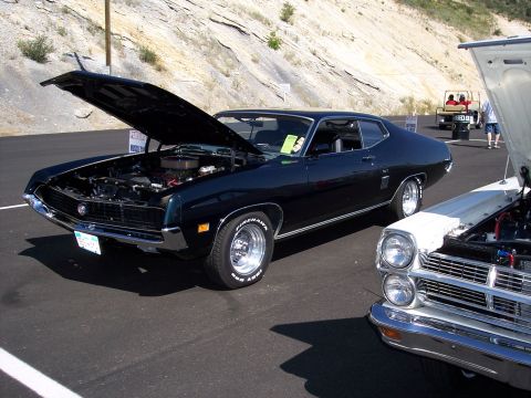 1972 Ford Ranchero - Two classic cars are parked on asphalt with a rocky hillside in the background.