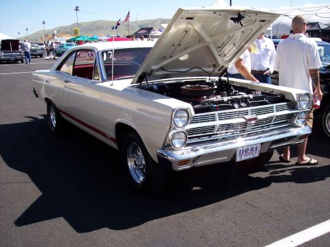 1972 Ford Ranchero - A white 1967 Ford Fairlane coupe is displayed with its hood open at an outdoor event.