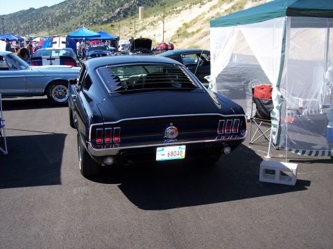 1972 Ford Ranchero - Rear view of a black 1967 Ford Mustang Fastback at an outdoor car show.