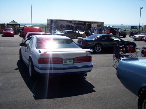 1972 Ford Ranchero - A white coupe with blue trim and a spoiler is parked at an outdoor event, seen from the rear.