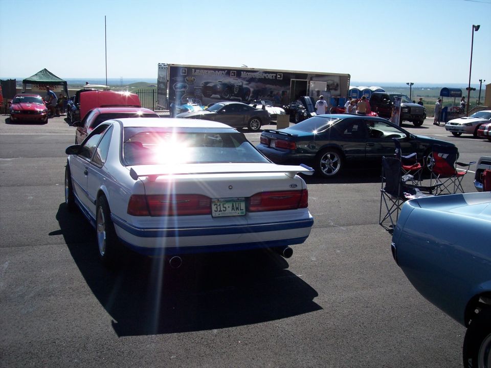 White coupe with blue trim and spoiler, rear view. License plate 315-AWL