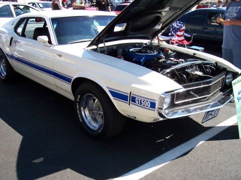 1972 Ford Ranchero - A classic white 1969 Ford Mustang GT500 is displayed with its hood open, revealing the engine bay.