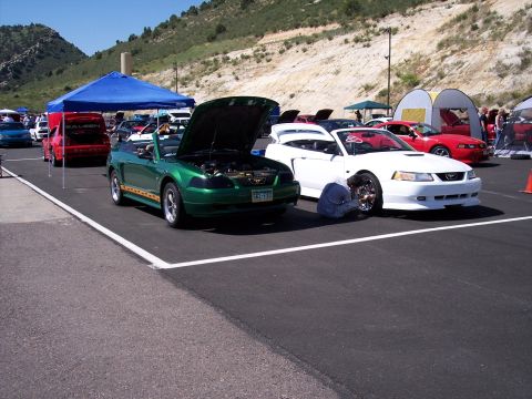 1972 Ford Ranchero - A green Ford Mustang convertible is displayed with its hood open at an outdoor car show.