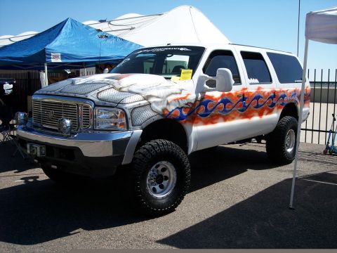 1972 Ford Ranchero - Customized Ford Excursion SUV with flame graphics and diamond plate hood wrap displayed outdoors.
