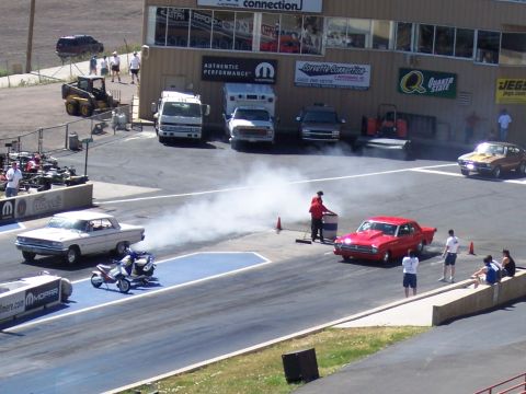 1972 Ford Ranchero - Cars and a scooter prepare for a drag race at Bandimere Speedway, with spectators watching from the stands.
