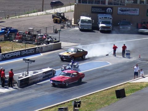 1972 Ford Ranchero - A gold muscle car performs a burnout on the drag strip, kicking up smoke during a race event.