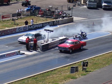 1972 Ford Ranchero - Drag racing at Bandimere Speedway features a red 1966 Ford Ranchero and a silver sedan.