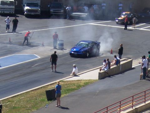 1972 Ford Ranchero - A blue muscle car performs a burnout on the drag strip, creating smoke as spectators observe.