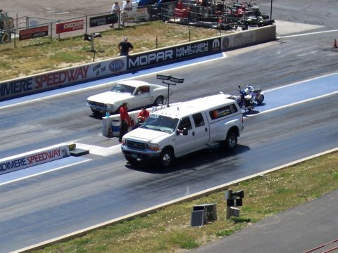 1972 Ford Ranchero - A white Ford F-Series truck and a white Ford Mustang are lined up on a drag strip at Bandimere Speedway.