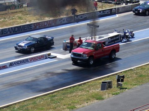 1972 Ford Ranchero - Two vehicles compete on a drag strip, with one emitting dark smoke.