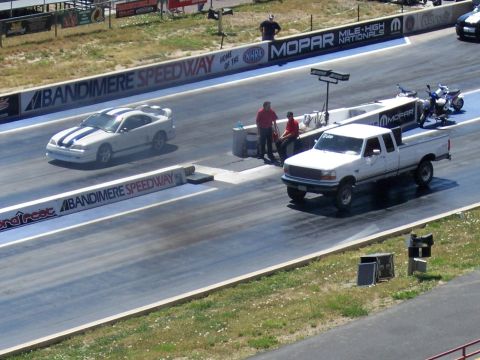 1972 Ford Ranchero - Two vehicles race down a drag strip with Mopar and NHRA banners visible in the background.