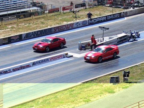 1972 Ford Ranchero - Two red Ford Mustangs compete on a drag strip at Bandimere Speedway.