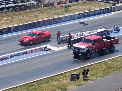 1972 Ford Ranchero - Two vehicles prepare for a drag race at Bandimere Speedway, with spectators in the background.