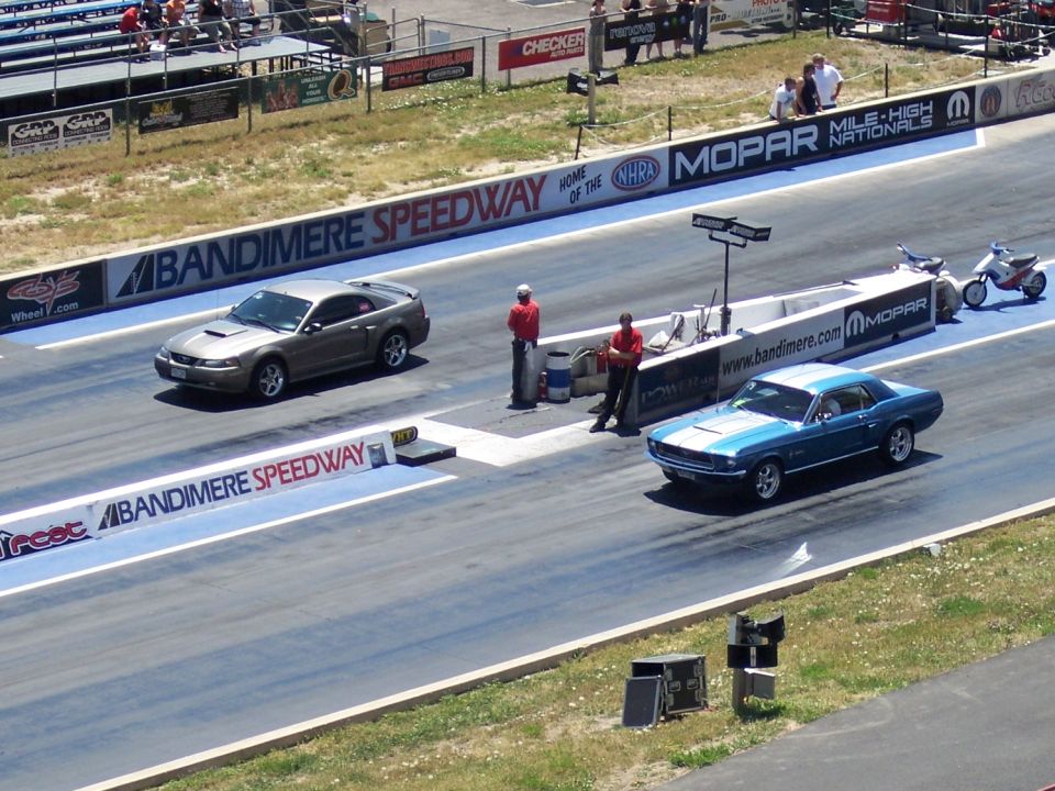 Blue 1969 Mustang and a silver Mustang on a drag strip