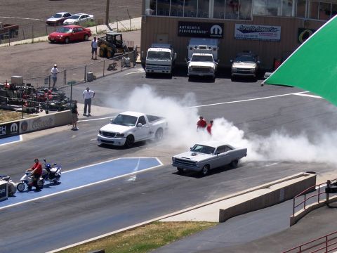1972 Ford Ranchero - A silver muscle car performs a burnout on the drag strip, kicking up a large cloud of smoke.