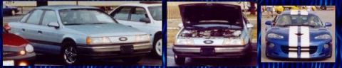 1991 Ford Taurus - 1991 Ford Taurus front view with hood open, parked with other vehicles.
