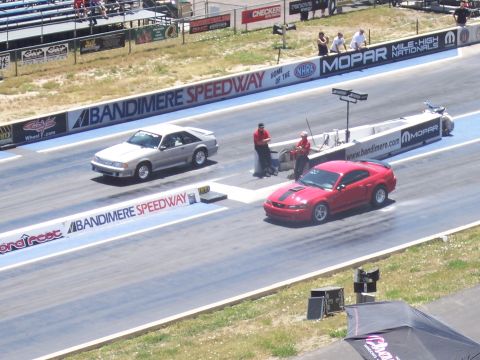 1972 Ford Ranchero - Two Ford Mustangs race down Bandimere Speedway, with spectators in the stands.