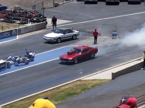 1972 Ford Ranchero - Two cars prepare for a drag race, one performing a burnout as smoke billows.