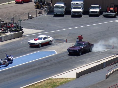1972 Ford Ranchero - Two cars, a Mustang and a Pinto, race down a drag strip while a motorcycle waits.