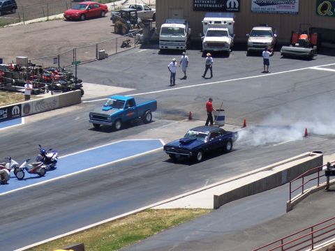 1972 Ford Ranchero - Two cars race down a drag strip, one producing tire smoke.