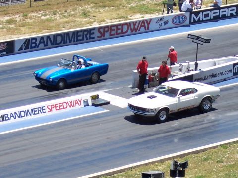 1972 Ford Ranchero - A white 1970 Ford Mustang drag car is on the right lane, while a blue convertible is on the left lane at Bandimere Speedway.