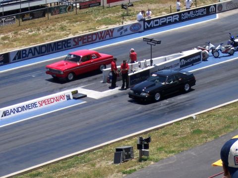 1972 Ford Ranchero - Two cars prepare for a drag race at Bandimere Speedway, with banners for Mopar and NHRA visible.