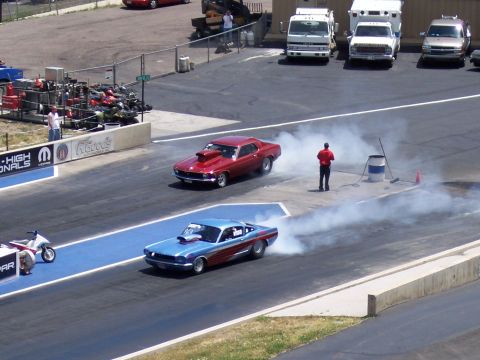 1972 Ford Ranchero - Two cars perform burnouts on a drag strip, creating large clouds of smoke.