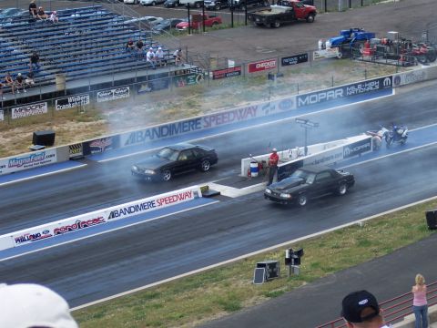 1972 Ford Ranchero - Cars compete in a drag race at Bandimere Speedway, with smoke billowing from their tires.
