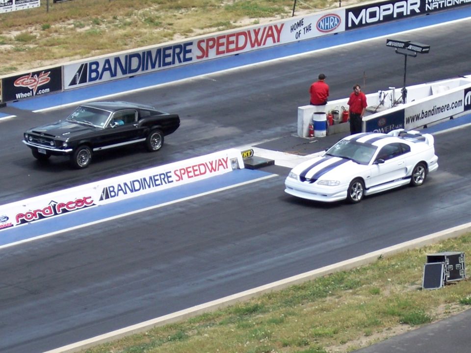 Black 1967-1968 Ford Mustang and white 1994-1998 Ford Mustang race at Bandimere Speedway