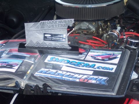 1972 Ford Ranchero - A trophy and photo album are displayed in the engine bay of a vehicle.