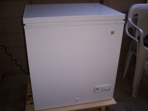 1989 Ford Bronco - A white chest freezer sits on a wooden pallet next to a plastic chair.