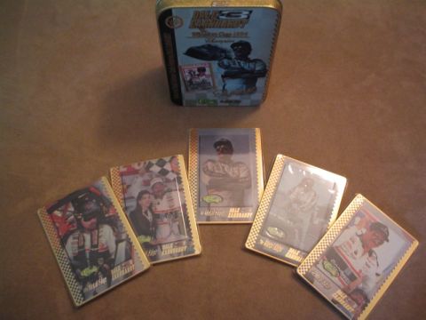 1998 Ford Crown Victoria - A collection of Dale Earnhardt trading cards and a commemorative tin are displayed on a brown surface.