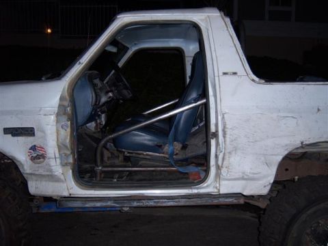 1995 Ford Bronco - Side view of a 1995 Ford Bronco's interior, modified with a roll cage and racing seats.