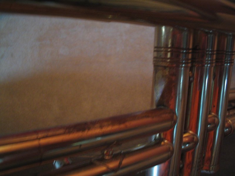 Close-up of trumpet valves and tubing, showing some wear