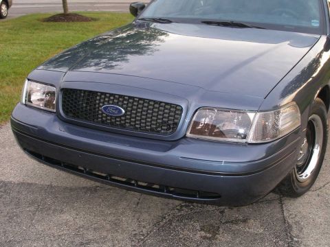 1998 Ford Crown Victoria - The front of a dark blue 1998 Ford Crown Victoria is shown, its grille and headlights.