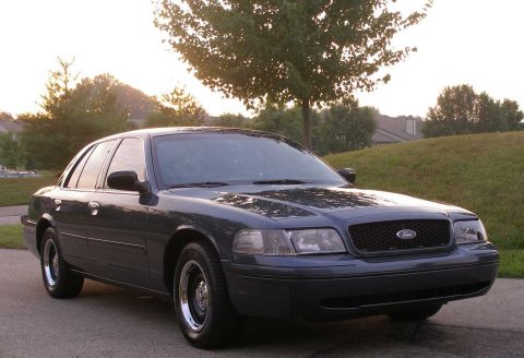 1998 Ford Crown Victoria - A dark blue 1998 Ford Crown Victoria sedan is shown from a three-quarter front angle.