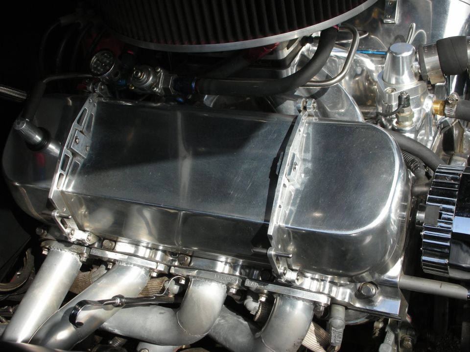 Chrome engine valve cover with silver brackets and exhaust headers