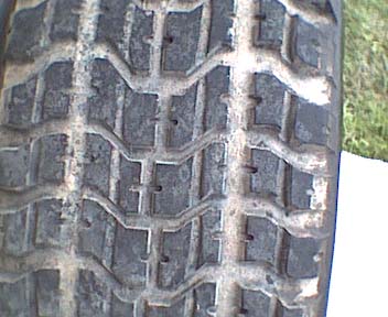 1989 Ford Bronco - A close-up view of a tire's tread pattern, the Supermotors.net logo in the corner.